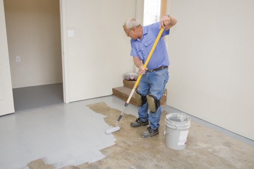 Contract painter painting garage floor to speed up selling of home