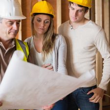 Construction worker showing couple blueprint
