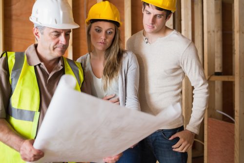 Construction worker showing couple blueprint